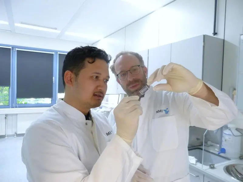 Tengku Ibrahim Maulana (links) und Prof. Peter Loskill, mit dem Chip, der Chancen eröffnet: Darauf lässt sich Tumorgewebe züchten, mit Zelltherapeutika behandeln und dann die Reaktion beobachten. Ein Schritt zu wirksameren und schonenderen Behandlungen | Copyright: Foto: NMI |