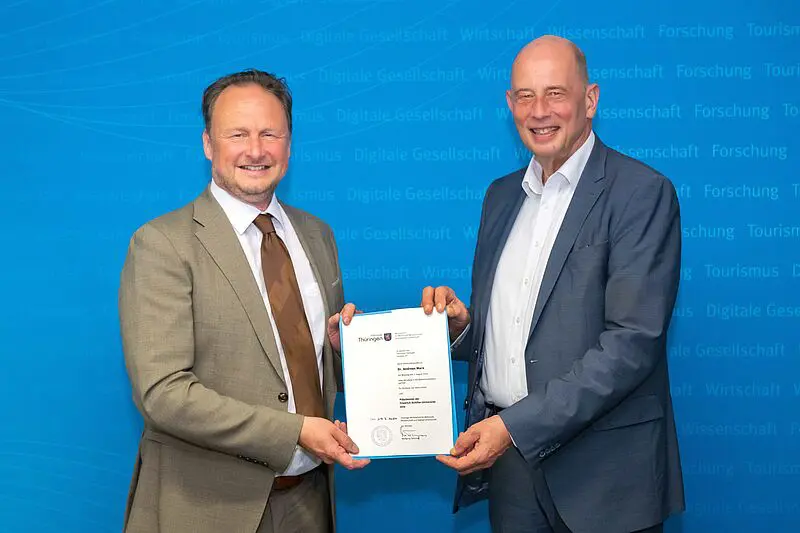 Prof. Dr. Andreas Marx (l.) erhält aus den Händen von Wolfgang Tiefensee, Thüringens Minister für Wirtschaft, Wissenschaft und Digitale Gesellschaft, die Ernennungsurkunde für seine 1. Amtszeit als Präsident der Friedrich-Schiller-Universität Jena. | Quelle: Foto: Jens Meyer/Uni Jena