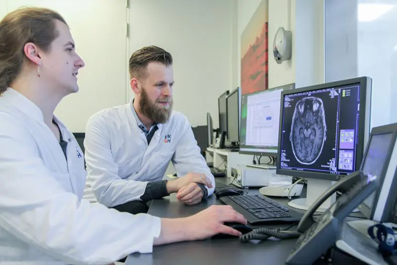 PD Dr. Jannik Prasuhn (re.) und Norman Griebner werten innovative MRT-Sequenzen aus, die biologisch-spezifische Veränderungen im Gehirn von Patientinnen und Patienten mit Parkinson-Krankheit sichtbar machen. | Copyright: UKSH